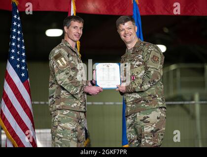 U.S. Air Force Col. Sean Lowe, 48th Operations Group commander, left, presents Lt. Col. Ryan Lippert, former 48th Operations Support Squadron commander, the Meritorious Service Medal during a change of command ceremony at Royal Air Force Lakenheath, England, June 4th, 2021. The Meritorious Service Medal is awarded to service members who have distinguished themselves through meritorious service or achievement. Stock Photo