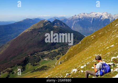 Slovenia, Julian Alps, WWI, mount Krasji seen from the steep slope of mount Vrata. In the background the Kanin group of mountains. On May 31st 1915, alang those steep slopes, the soldiers of Battaglione Alpino Susa launched the attack to conquer the Austro-Hungarian post of the Vrata saddle and the ridge of mount Vrsic. In a picture a climber. Stock Photo