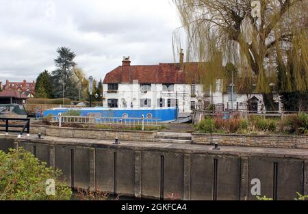 A narrowboat passes through Sandford Lock on the River Thames Oxford with The Kings Arms pub in the background Stock Photo