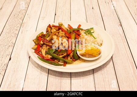 Plate of Mexican chicken fajitas with sautéed peppers, rice and chipotle Stock Photo
