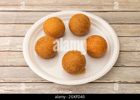 Colombian corn flour fritters on white plastic plate Stock Photo