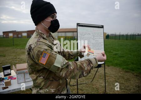 U.S. Army Spc. Avery Harris, an Orderly Room clerk with the 39th Strategic Signal Battalion, holds a period of instruction on the M8 chemical agent detector paper during the unit’s yearly Chemical, Biological, Radiological and Nuclear defense training on Chièvres Air Base, Belgium, April 8, 2021. In order to stay proficient on their CBRN equipment and procedures the unit conducted training to ensure readiness and fulfill their annual requirements. Stock Photo