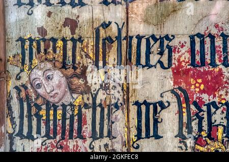 Binham Priory rood screen.  Mediaeval painting of St Catherine showing through black-letter overpainted text from Cranmer's bible of 1539. Stock Photo