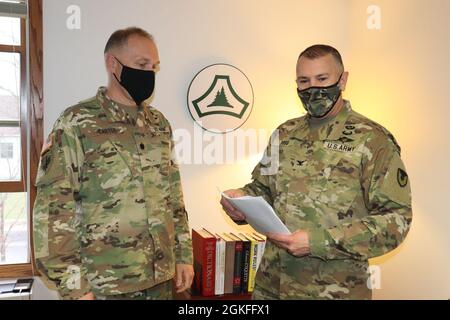 Garrison Commander Col. Michael Poss (right) congratulates Deputy Garrison Commander Lt. Col. Alexander Carter on April 8, 2021, after learning that Carter was been selected for promotion to colonel (O-6) at Garrison Headquarters at Fort McCoy. Being selected for O-6, Carter now has further leadership and command opportunities open to him. Stock Photo