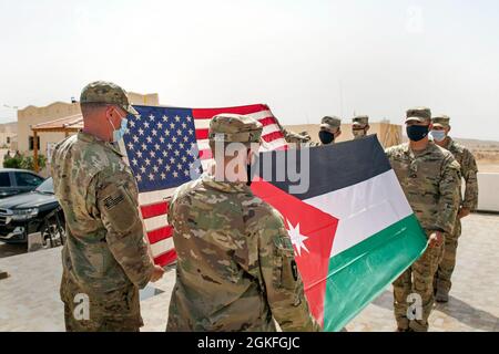 The Jordanian Armed Forces, Southern Command, 3rd Border Guard Group Commander, Col. Ra'ad Al Aamayra, and Task Force Spartan Division Tactical- Jordan Officer in Charge, Col. Christopher Fletcher, exchange flags in a symbolic gesture of friendship and partnership following the successful completion of the Desert Warrior 21 live-fire exercise, April 8, 2021. The exercise was viewed by JAF General Officers and senior leaders from U.S. Army Central and TF Spartan. Moments of expressed gratitude help to solidify the enduring relationship between the two forces. Stock Photo