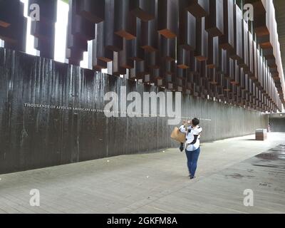 Senior Master Sgt. Tonya Taplin, 403rd Logistics Readiness Squadron plans superintendent, takes a photo of a quote on the wall of the National Memorial for Peace and Justice while walking below the six-foot tall steel columns which hung suspended overhead, each marked with a county, state, and the lynching victims' names, April 9, 2021 during the 403rd Mission Support Group leadership staff ride. Members of the 403rd MSG leadership participated in a non-traditional staff ride, which involves walking a battlefield, only in this case the battle that was fought was the Civil Rights Movement for A Stock Photo