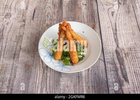 fried prawns battered with panko on lettuce and a plate from a Chinese restaurant Stock Photo