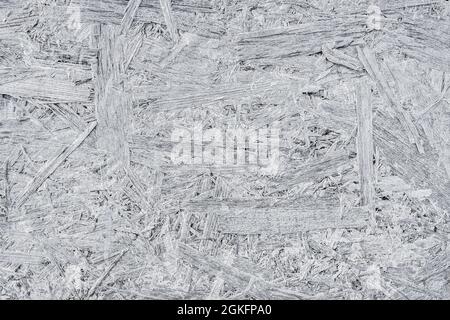 Gray fiberboard background, wood processing waste, texture of a pressed wood. Stock Photo