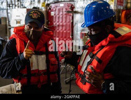 PACIFIC OCEAN (April 9, 2021) U.S. Navy Mineman 2nd Class Samuel Vazquez , left, and Engineman 1st Class Marcus D. Alford , participate in a risk assessment meeting with members from U.S. Coast Guard Law Enforcement Detachment 106 during an Oceania Maritime Security Initiative (OMSI) training evolution aboard Independence-variant littoral combat ship USS Tulsa (LCS 16). The OMSI program, is a Secretary of Defense program leveraging Department of Defense assets transiting the region to increase the Coast Guard's maritime domain awareness, ultimately supporting its maritime law enforcement opera Stock Photo