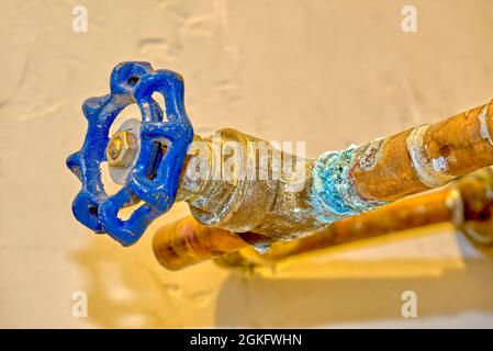 An old copper water valve that is badly corroded and leaking. Stock Photo