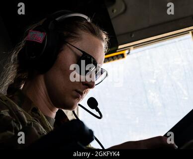 A U.S. Air Force C-17 Globemaster III aircraft pilot assigned to the 816th Expeditionary Airlift Squadron, checks her ipad over the U.S. Central Command area of responsibility, April 12, 2021. The C-17 is capable of rapid strategic delivery of troops and all types of cargo to main operating bases or directly to forward bases in the U.S. Central Command area of responsibility. Stock Photo