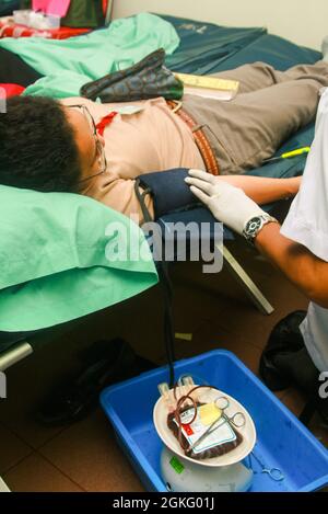A blood donor is having her blood pressure checked by a health worker during a blood donation event. Stock Photo