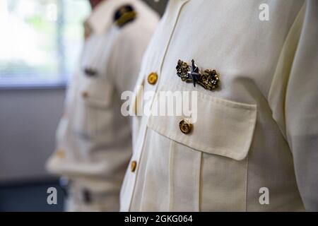 Members of the 11th Regional Japan Coast Guard (JCG) stand at attention as a Certificate of Commendation is read while at the 11th Regional JCG Station in Nakagusuku, Okinawa, Japan, April 13, 2021. On Feb. 15, 2021, members of the 11th Regional JCG responded to a distress call involving seven U.S. Marines recreationally kayaking off the coast of Camp Schwab. The coast guardsmen were awarded for their timely and professional response to the situation and the successful safe return of every service member involved. Stock Photo