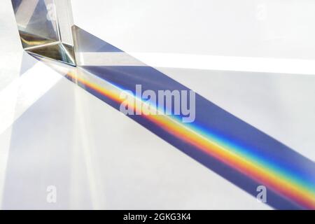 Glass prism for optical physics experiments in education, splitting the light into reflection beams in the spectrum of rainbow colors, bright backgrou Stock Photo