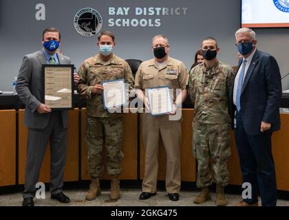 From left to right, Steve Moss, Bay District school board chairman, U.S. Air Force Col. Greg Moseley, 325th Fighter Wing commander, U.S. Navy Cmdr. Keith Foster, Naval Support Activity Panama City commanding officer, U.S. Air Force Lt. Col. Rigoberto Perez, 325th Force Support Squadron commander, and Bill Husfelt, Bay District school board superintendent, pose for a photo at Panama City, Florida, April 13, 2021. Leadership from Tyndall Air Force Base and Naval Support Activity Panama City signed an annual proclamation with the Bay District school board, designating April as Month of the Milita Stock Photo