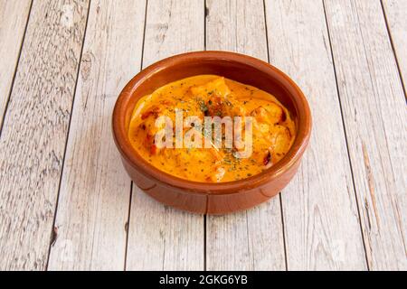 Clay pot with serving of mild curry, korma, chicken on light wooden table Stock Photo