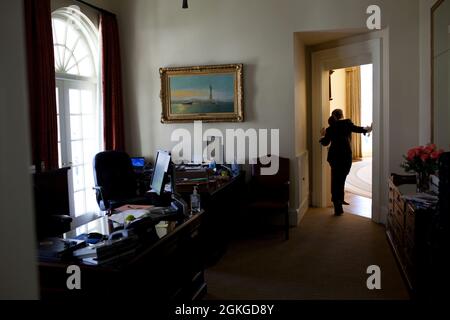 Katie Johnson, President Barack Obama's personal secretary, leans into the Oval Office to alert the President to an incoming phone call, March 20, 2010. (Official White House Photo by Pete Souza) This official White House photograph is being made available only for publication by news organizations and/or for personal use printing by the subject(s) of the photograph. The photograph may not be manipulated in any way and may not be used in commercial or political materials, advertisements, emails, products, promotions that in any way suggests approval or endorsement of the President, the First F