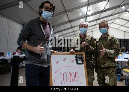 U.S. Air Force Lt. Col. Mike Ballak (right), commander of the 64th Air Expeditionary Group, stands with Senior Airman Daschia Lawrence, 92nd Health Care Operations Squadron (center), and Marc Ho, a data engineer based in Minneapolis, Minnesota (left). Mr. Ho received the 10,000th vaccine since the start of operations at the Community Vaccination Center (CVC) in St. Paul, Minnesota, on April 16, 2021. The CVC is now completely operational and welcoming the St. Paul community. U.S. Northern Command, through U.S. Army North, remains committed to providing continued, flexible Department of Defense Stock Photo