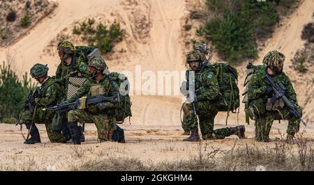 Canadian Land forces soldiers of the Royal Canadian Dragoons, 2nd Canadian Mechanized Brigade Group, sets up security in the early morning hours of Apr. 16. The unit was on a joint exercise with 3rd Battalion, 1st Combat Aviation Brigade, 1st Infantry Division, to clear the area of enemy in the mountainous wooded border region near Lielvarde, Latvia. Stock Photo