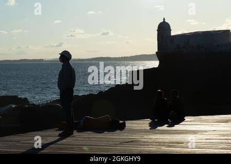 Salvador, Bahia, Brazil - June 17, 2021: Silhouette of a person enjoying the sea from Porto da Barra in Salvador, Bahia. Stock Photo