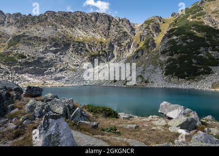 Glacial lake and impressive, rocky, barren mountain ranges on Rila, on the hiking track to Musala summit Stock Photo