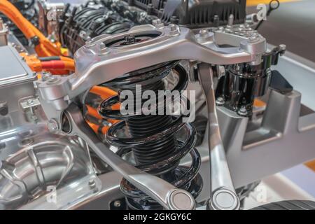 Detailed closeup of an electric car shock absorber system and engine spare parts. Stock Photo