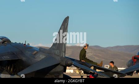 Marine Pfc. A.J. Wagner, a plane captain in training with Marine Attack Squadron 223, Cherry Point, North Carolina, slides down the wing of an AV-8B Harrier at Gowen Field, Boise, Idaho, April 19, 2021. The slide is an easy way for the Marines to get down from the aircraft. Stock Photo