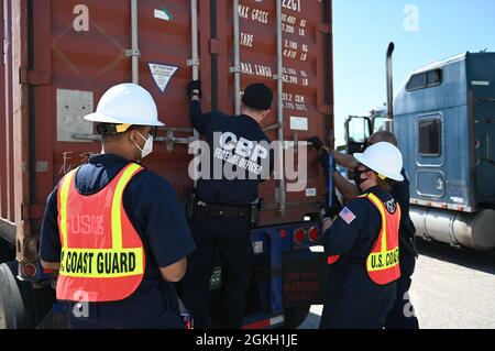 U.S. Coast Guard Chief Petty Officer Kerry Bolen, Port Safety and Security Chief for Coast Guard Sector Maryland-National Capital Region, and Ens. Arnoldo Espinal, a member of the Port Safety and Security inspection team from Coast Guard Sector Maryland-National Capital Region, inspects a container to look for undeclared hazards in conjunction with U.S. Customs and Border Protection Federal officers during a multi-agency strike force operation at the Port of Baltimore, April 20, 2021. A MASFO is conducted to ensure the safe and legal transportation of containerized cargo. Stock Photo