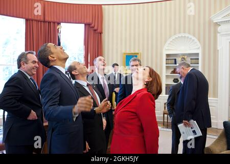 President Barack Obama, Prime Minister Julia Gillard of Australia, and members of the Australian and American delegations look up at the presidential seal in the Oval Office ceiling following their bilateral meeting, March 7, 2011. (Official White House Photo by Pete Souza) This official White House photograph is being made available only for publication by news organizations and/or for personal use printing by the subject(s) of the photograph. The photograph may not be manipulated in any way and may not be used in commercial or political materials, advertisements, emails, products, promotions Stock Photo