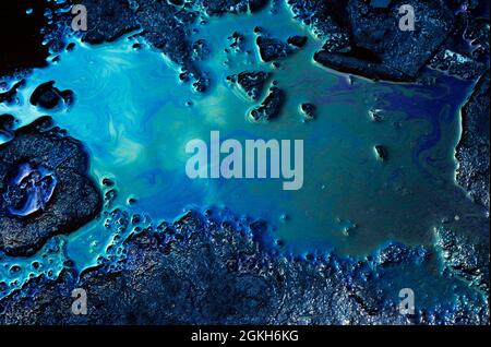 1970s CLOUDS IN BLUE SKY REFLECTED IN POLLUTION OIL SLICK ON RAIN WATER PUDDLE IN ASPHALT ROAD POTHOLE  - 007921 PEA001 HARS POLLUTING REFLECTED SLIME IRIDESCENT OLD FASHIONED PUDDLE Stock Photo