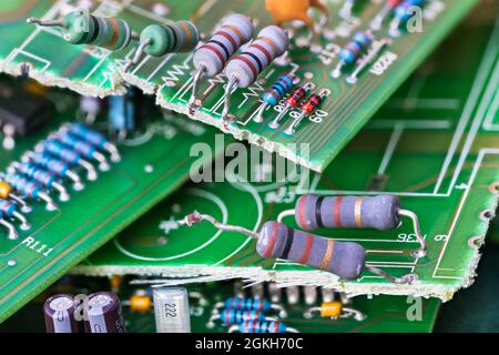 WasE-waste heap of broken green printed circuit boards and electrical components. Waste disposal. Resistors, capacitors or diodes Electronics industry. Stock Photo