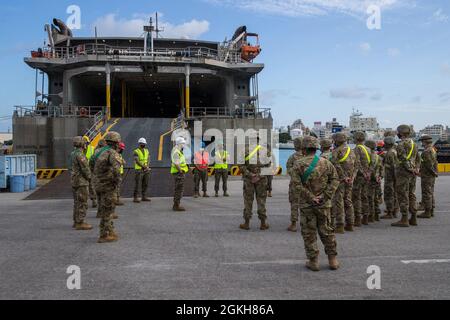 U.S. Marines with III Marine Expeditionary Force and U.S. Army soldiers with 1st Battalion, 1st Air Defense Artillery, gather outside the USNS Guam (T-HST-1) in preparation for a Joint Mobility Exercise at Naha Military Port, Okinawa, Japan, April 21, 2021. The exercise tested the capability of lift support to units and gear that are uncommon to traditional Marine Corps conveyance planning. Stock Photo