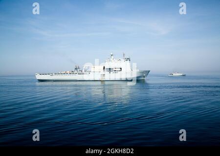 210420-A-MU580-1153 ARABIAN GULF (April 20, 2021) - Royal Fleet Auxiliary landing ship dock RFA Cardigan Bay (L 3009), left, operates with Royal Navy minehunter HMS Penzance   (M106) during exercise Artemis Trident 21 in the Arabian Gulf, April 20. Artemis Trident 21 is a multilateral mine countermeasures exercise between the UK, Australia, France and U.S., designed to enhance mutual interoperability and capabilities in mine hunting and clearance, maritime security and dive operations, allowing participating naval forces to effectively develop the necessary skills to address threats to regiona Stock Photo