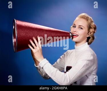 1950s BLONDE WOMAN COLLEGE CHEERLEADER IN LETTER SWEATER LOOKING AT CAMERA YELLING INTO MEGAPHONE - g1396c HAR001 HARS SHOUT MEGAPHONE CHEERLEADER PLEASED JOY LIFESTYLE STUDIO SHOT COPY SPACE PEOPLE CHILDREN HALF-LENGTH INSPIRATION ENTERTAINMENT LEADING YELLING EYE CONTACT GOALS SUCCESS HAPPINESS HEAD AND SHOULDERS CHEERFUL VICTORY CHEER EXCITEMENT LEADERSHIP CHEERLEADERS LIPSTICK PRIDE HIGH SCHOOL SMILES SWEATERS ENCOURAGE JOYFUL STYLISH SUPPORT TEENAGED YELL ENCOURAGEMENT COMMUNICATE ENCOURAGING MEGAPHONES YOUNG ADULT WOMAN CAUCASIAN ETHNICITY HAR001 OLD FASHIONED Stock Photo