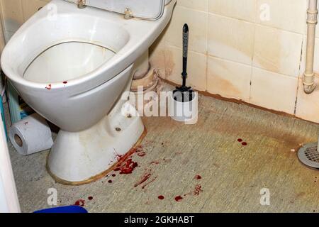 Blood stain on the floor in the bathroom near the toilet Stock Photo