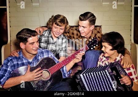 1950s TWO COUPLES TEEN BOYS GIRLS SINGING PLAYING GUITAR & ACCORDION WEARING PLAID SHIRTS - j3390c LAN001 HARS 4 OLD TIME NOSTALGIA OLD FASHION 1 JUVENILE STYLE COMMUNICATION SINGER YOUNG ADULT PLEASED JOY LIFESTYLE SOUND MUSICIAN CELEBRATION GROWNUP HEALTHINESS HOME LIFE COPY SPACE PEOPLE CHILDREN FRIENDSHIP PERSONS GROWN-UP TEENAGE GIRL TEENAGE BOY PLAID SING ENTERTAINMENT CONFIDENCE B&W QUARTET HAPPINESS ACCORDION HEAD AND SHOULDERS CHEERFUL SHIRTS SONG VOICE VOCAL SMILES JOYFUL STYLISH TEENAGED JUVENILES TOGETHERNESS YOUNG ADULT MAN YOUNG ADULT WOMAN BLACK AND WHITE CAUCASIAN ETHNICITY Stock Photo