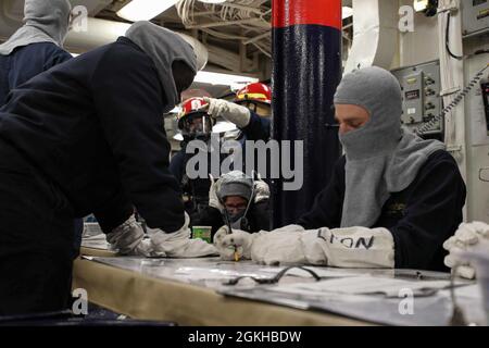 ENGLISH CHANNEL (April 20, 2021) Ensign Ndeye Lam, left, and Ensign Donovan Lyon, right, track hose team manning during a general quarters drill aboard the Arleigh Burke-class guided-missile destroyer USS Ross (DDG 71) during Flag Officer Sea Training (FOST), April 22, 2021. FOST is a three-week exercise led by the Royal Navy that tests the ship’s warfighting ability. Ross, forward-deployed to Rota, Spain, is on patrol in the U.S. Sixth Fleet area of operations in support of regional allies and partners and U.S. national security interests in Europe and Africa. Stock Photo