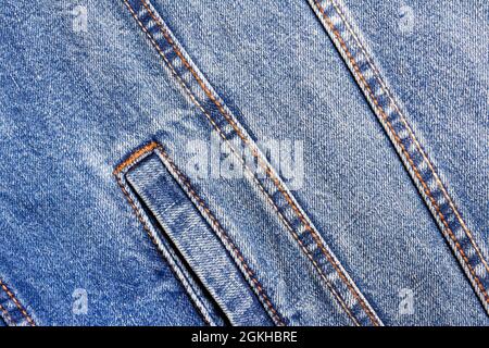 Texture backdrop photo of blue colored denim cloth with seams and pocket. Stock Photo