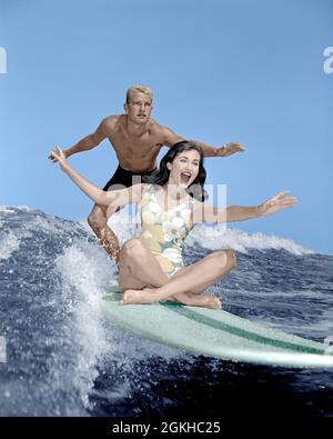 1960s COUPLE LAUGHING WOMAN SITTING ON SURFBOARD WITH MAN STANDING ARMS OUT FOR BALANCE LOOKING SERIOUS - ka9359 CYP001 HARS OLD FASHION 1 FITNESS HEALTHY YOUNG ADULT BALANCE TEAMWORK VACATION SURFING WAVES ATHLETE JOY LIFESTYLE SPEED FEMALES MARRIED SPOUSE HUSBANDS GROWNUP ATHLETICS COPY SPACE FRIENDSHIP FULL-LENGTH LADIES PHYSICAL FITNESS PERSONS GROWN-UP MALES TEENAGE GIRL TEENAGE BOY ATHLETIC PAIRS SURF MEN AND WOMEN PARTNER TIME OFF SKILL ACTIVITY PHYSICAL THRILL ADVENTURE STRENGTH TRIP GETAWAY EXCITEMENT LOW ANGLE RECREATION HOLIDAYS RELATIONSHIPS SURFERS ATHLETES FLEXIBILITY MUSCLES Stock Photo