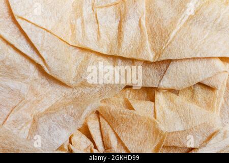 Texture backdrop photo of orange colored creased wrapping paper. Stock Photo