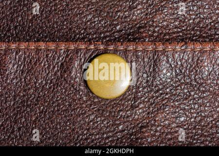 Texture backdrop photo of brown colored suede leather pocket with copper button. Stock Photo