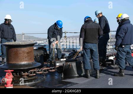 PLYMOUTH, England (April 23, 2021) Sailors aboard the Arleigh Burke-class guided-missile destroyer USS Ross (DDG 71) moor the ship to a buoy in Plymouth, England during Flag Officer Sea Training (FOST), April 23, 2021. FOST is a three-week exercise led by the Royal Navy that tests the ship’s warfighting ability. Ross, forward-deployed to Rota, Spain, is on patrol in the U.S. Sixth Fleet area of operations in support of regional allies and partners and U.S. national security interests in Europe and Africa. Stock Photo