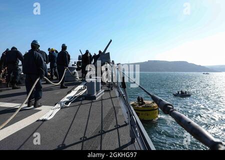 PLYMOUTH, England (April 23, 2021) Sailors aboard the Arleigh Burke-class guided-missile destroyer USS Ross (DDG 71) moor the ship to a buoy in Plymouth, England during Flag Officer Sea Training (FOST), April 23, 2021. FOST is a three-week exercise led by the Royal Navy that tests the ship’s warfighting ability. Ross, forward-deployed to Rota, Spain, is on patrol in the U.S. Sixth Fleet area of operations in support of regional allies and partners and U.S. national security interests in Europe and Africa. Stock Photo