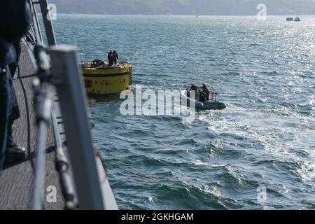 PLYMOUTH, England (April 23, 2021) Sailors aboard the Arleigh Burke-class guided-missile destroyer USS Ross (DDG 71) moor the ship to a buoy in Plymouth, England during Flag Officer Sea Training (FOST), April 23, 2021. FOST is a three-week exercise led by the Royal Navy that tests the ship’s warfighting ability. Ross, forward-deployed to Rota, Spain, is on patrol in the U.S. Sixth Fleet area of operations in support of regional allies and partners and U.S. national security interests in Europe and Africa. Stock Photo