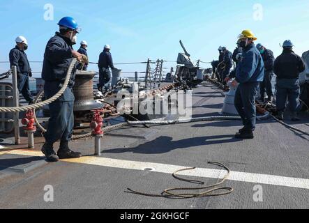 PLYMOUTH, England (April 23, 2021) Sailors aboard the Arleigh Burke-class guided-missile destroyer USS Ross (DDG 71) moor the ship to a buoy in Plymouth, England during Flag Officer Sea Training (FOST), April 23, 2021. FOST is a three-week exercise led by the Royal Navy that tests the ship’s warfighting ability. Ross, forward-deployed to Rota, Spain, is on patrol in the U.S. Sixth Fleet area of operations in support of regional allies and partners and U.S. national security interests in Europe and Africa. Stock Photo