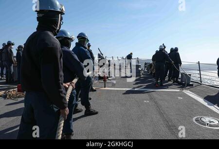 PLYMOUTH, England (April 23, 2021) Sailors aboard the Arleigh Burke-class guided-missile destroyer USS Ross (DDG 71) moor the ship to a buoy in Plymouth, England during Flag Officer Sea Training (FOST), April 23, 2021. FOST is a three-week exercise led by the Royal Navy that tests the ship’s warfighting ability. Ross, forward-deployed to Rota, Spain, is on patrol in the U.S. Sixth Fleet area of operations in support of regional allies and partners and U.S. national security interests in Europe and Africa. Stock Photo