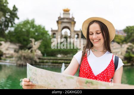 Female tourist checking a map while visiting Ciutadella Park in Barcelona Stock Photo