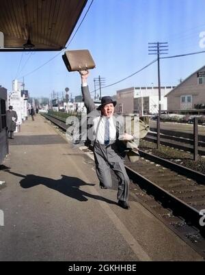 1950s DISTRESSED MAN LATE BUSINESSMAN WITH BRIEFCASE IN AIR RUNNING CALLING YELLING AFTER DEPARTING COMMUTER TRAIN - r5317c DEB001 HARS MAD EXECUTIVE OLD TIME TRACK RACING NOSTALGIA TRAINS OLD FASHION 1 SCREAM ANGER SHOUT RAILROAD LIFESTYLE ANNOYED HOME LIFE TRANSPORT COPY SPACE FULL-LENGTH PERSONS MALES AMERICANA TRANSPORTATION AFTER B&W LATE TRACKS YELLING COMMUTE RUSH RAIL OCCUPATION PLATFORM RUSHING EXCITEMENT STRESSFUL OFFICE WORKER DEPART FRUSTRATION OCCUPATIONS SUSPENDERS BREADWINNER BUSINESS MAN BUSINESS MEN BUSINESS PEOPLE MISSED ATTACHE BUSINESSPEOPLE BUSINESSPERSON DELIVER YELL Stock Photo