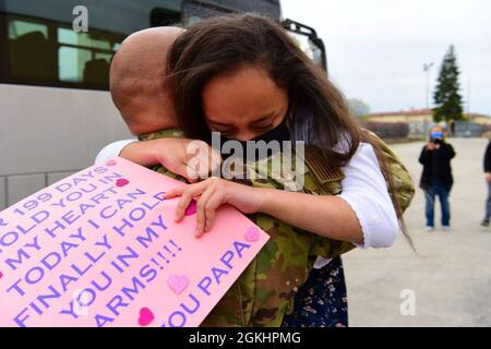 An Airman assigned to the 606th Air Control Squadron (ACS) hugs his daughter at Aviano Air Base, Italy, April 26, 2021. Approximately 100 Airmen from 606th ACS deployed for six months to various locations in Southeast Asia, providing real-time battlespace pictures for operators to control aircraft within their area of responsibility. Stock Photo