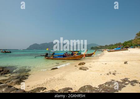 Long tail boats moored on a beach on Phi Phi island in Thailand Stock Photo